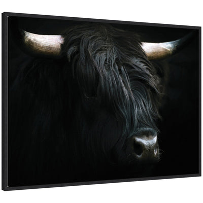 Framed canvas of a minimalist black Highland cow artwork by Michael Schauer showing the cow’s face with long horns against a white background