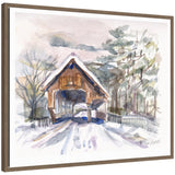 Framed canvas art showing a snowy covered bridge in Vermont surrounded by trees, painted in delicate watercolor by Patricia Shaw.