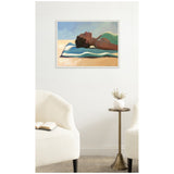 Framed canvas print of a woman in a green swimsuit lying on a blue and white striped towel under a clear sky, displayed on a white wall between two white chairs and a small round table.