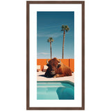 Framed Art featuring a bison lounging by a turquoise pool with two palm trees and an orange wall background