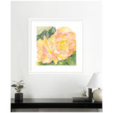 Framed watercolor painting of two orange and pink begonia flowers with green leaves, displayed on a white wall above a black shelf with a plant and a lamp.