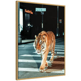 Framed canvas showing an orange and black striped tiger walking across a nighttime urban crosswalk under streetlights.