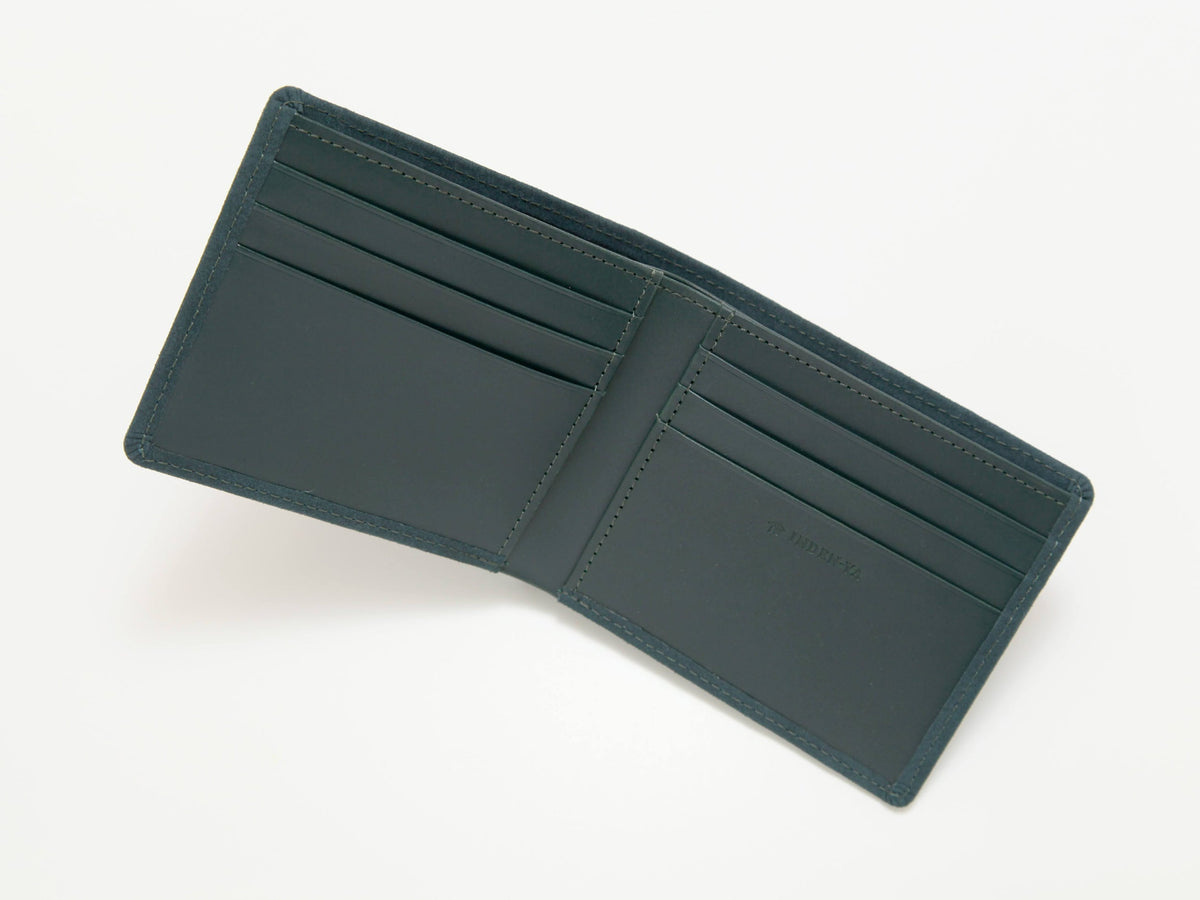 Dark green leather folded wallet opened flat showing six card slots and a central bill compartment with minimal stitching detail.