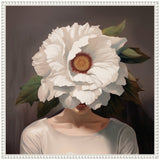 Portrait of a woman with a large white flower covering her face, surrounded by green leaves, against a muted brown background, framed in white.