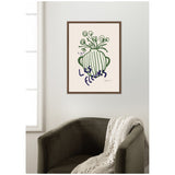 Minimalist wall art of a green striped vase with swirling stems and cursive text 'Les Fleurs' in dark blue, framed and hanging above a dark green armchair with a cream knit throw.