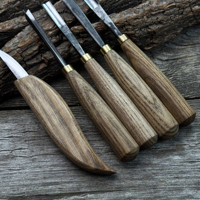 5-piece wood carving tool set with whittling knife and four chisels on wooden surface