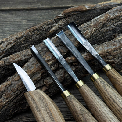 5-piece wood carving tool set with whittling knife and four chisels on wooden surface