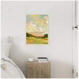 Impressionistic landscape painting with vibrant orange, green, and blue brushstrokes depicting sky, clouds, and trees, in a simple white frame on a white wall.
