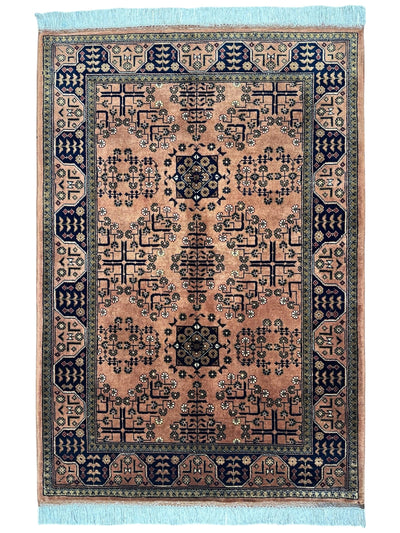 Hand-Knotted Bukharayi Rug in peach, red, ivory, and gold tones with traditional Afghan wool design, displayed on wooden floor