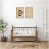 Two vintage-style framed canvases with baseball glove and ball artwork, hung above a wooden bench with white cushions in a minimalist room with a potted plant and woven rug.