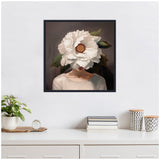 Portrait of a woman with a large white flower covering her face, set against a dark background with green leaves, in a black framed square canvas.