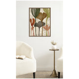 Abstract botanical wall art with layered leaves in earthy tones of green, brown, and rust, framed and hung on white wall above a small brass side table.