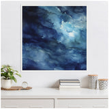 Abstract canvas with swirling deep and light blue tones resembling water or sky, framed in white and hung above a white shelf with plants and decor.