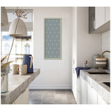 Narrow kitchen with gray stone countertops and light tile floor, featuring a framed blue botanical block print with white leaf patterns on the wall.