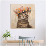 Painting of a brown tabby cat with green eyes adorned with a crown of pink, orange, and red flowers, displayed above a light wooden desk with a plant and chair.