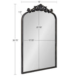 Rectangular mirror with an arched top measuring 30.75 inches high and 19 inches wide, featuring a dark frame and a decorative ornate scroll design at the top center.