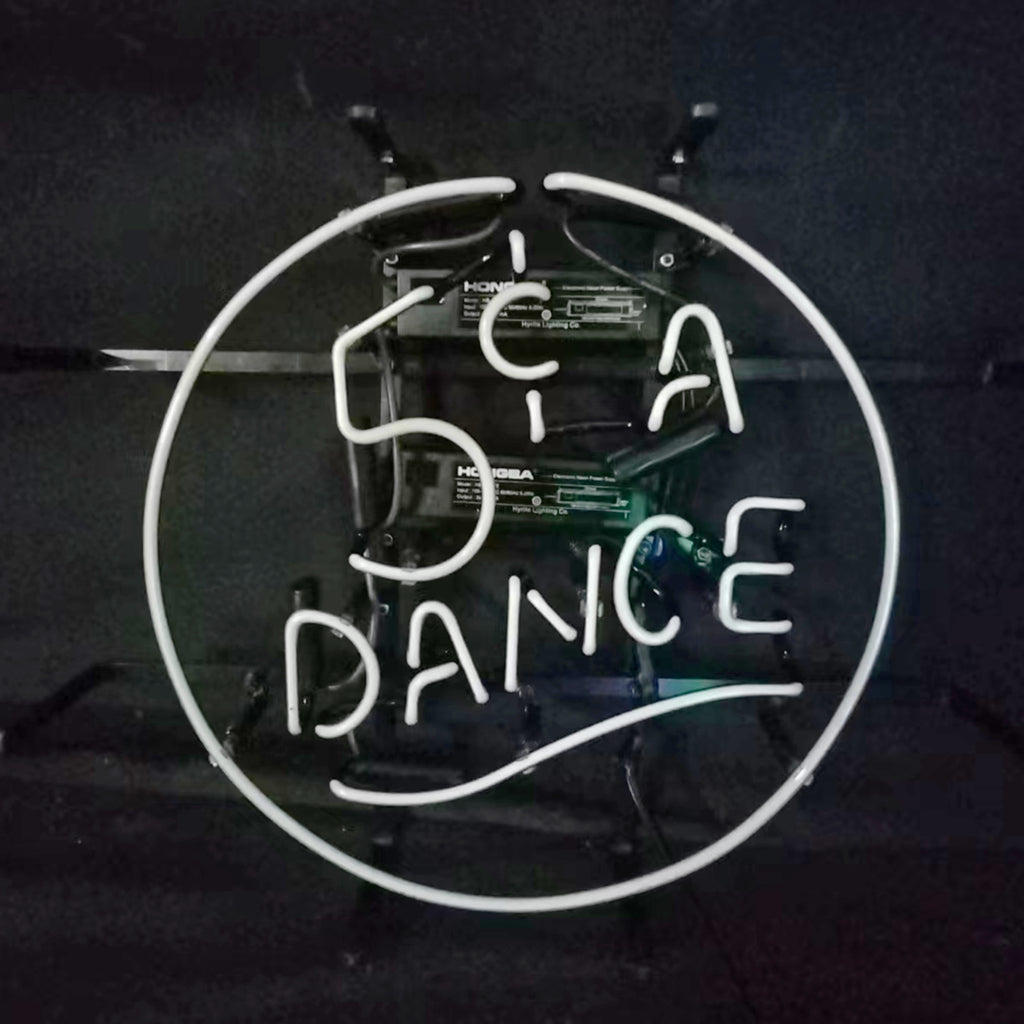 Round white neon sign with text "5¢ A DANCE" in capital letters against a dark background.