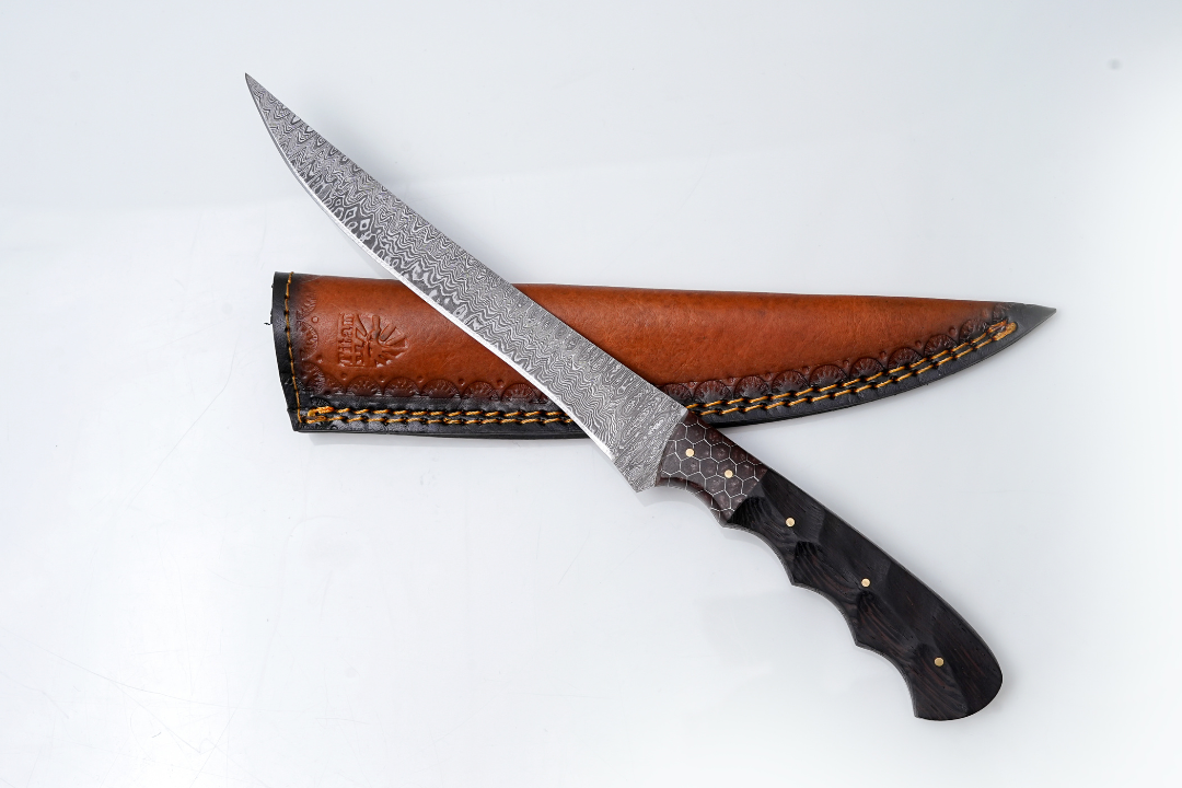 Titan International Knives Damascus Steel Fillet Knife with honeycomb bolster and dark wood textured handle alongside hand-tooled brown leather sheath