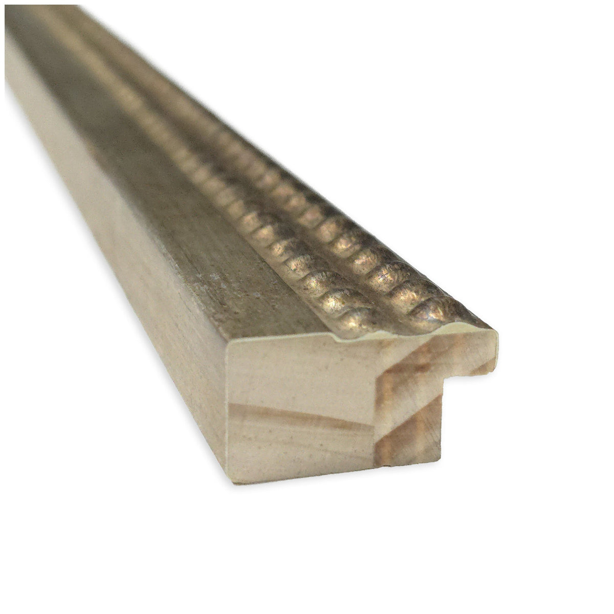Close-up of a wood frame molding with a textured, beaded gold upper edge and a smooth, light wood lower section, shown from a diagonal angle.