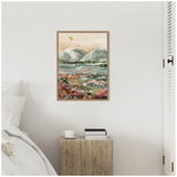 Framed canvas painting of a soft neutral-toned landscape with snow-capped mountains, green hills, and colorful wildflowers under a muted sky, hanging above a rustic wooden nightstand.