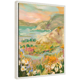 Framed canvas painting of a coastal landscape with wildflowers in foreground and soft pastel hills and water in the background under a warm sky.