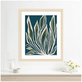 Framed abstract botanical print with elongated beige and green leaves outlined in white against a deep teal background, displayed on a white wall above a light wooden shelf.