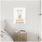Wall-mounted framed canvas showing a white alpaca behind a stack of pastel-colored folded towels with the text 'fluff and fold AT YOUR SERVICE.'