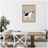 Minimalist framed canvas art of a white and black goat with brown face details on a muted taupe background hanging above a wooden dining table with white cross-back chairs and a cushioned bench.