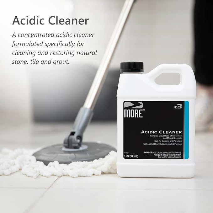 White plastic jug of MORE Acidic Cleaner with black label placed on tiled floor beside a mop with white microfiber head in a bright room.
