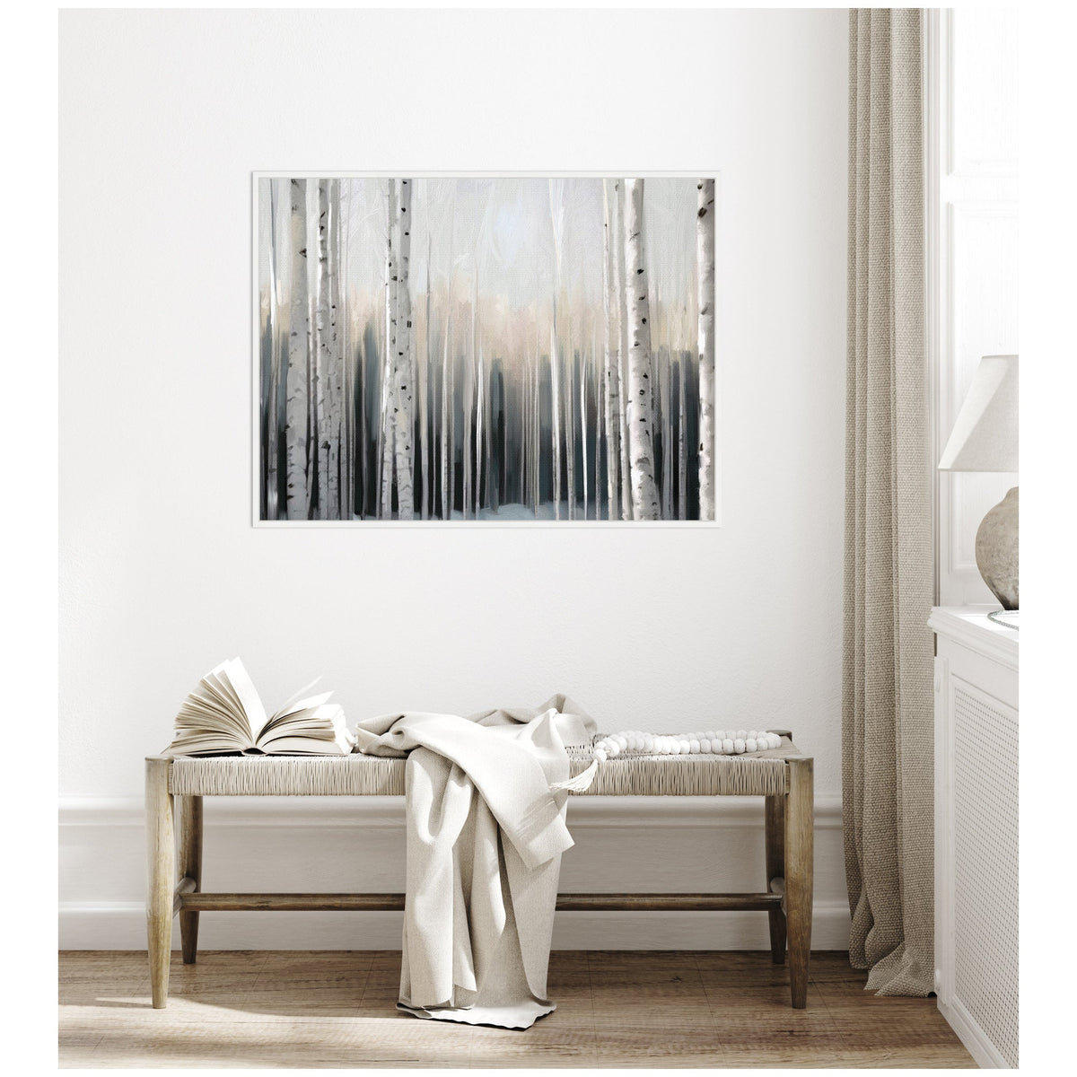 Framed canvas art depicting a foggy birch tree forest in muted grays and whites, hanging above a wooden bench with a draped light blanket and open book.