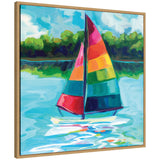 Framed canvas painting of a sailboat with colorful striped sails in red, pink, yellow, green, and blue, floating on bright blue water with green treeline reflection.
