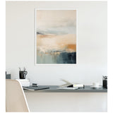 Abstract coastal-themed canvas print with soft beige, blue, and gray tones hanging above a black desk featuring office supplies and a white chair.
