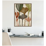 Framed canvas wall art featuring abstract botanical shapes in earthy tones of olive green, rust, brown, and beige, hanging above a minimalist desk setup.