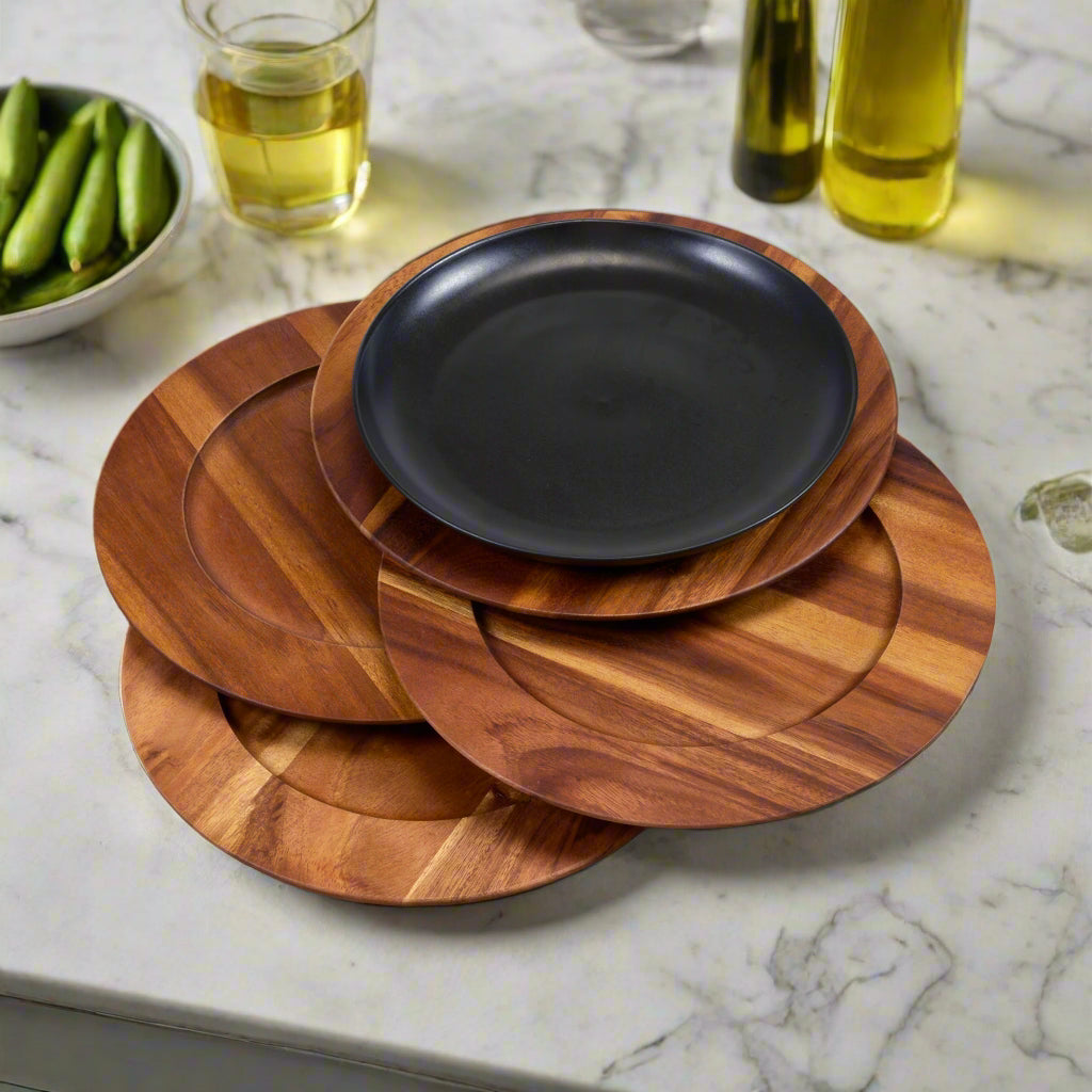 Set of four square-shaped charger plates made of Acacia wood with visible natural grain patterns