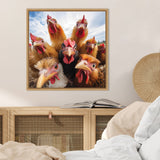 Square framed photograph of eight curious chickens, including a black one, with bright red combs against a blue sky, hanging above a wooden cabinet in a neutral-toned room.