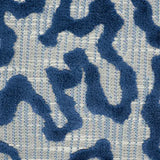 Close-up of Janis velvet pillow cover featuring irregular raised blue velvet shapes on a finely woven gray and cream background.