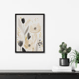 Framed abstract floral print featuring beige and black flowers with soft gray leaves and golden dot accents, hanging above a black shelf with potted plants and books.