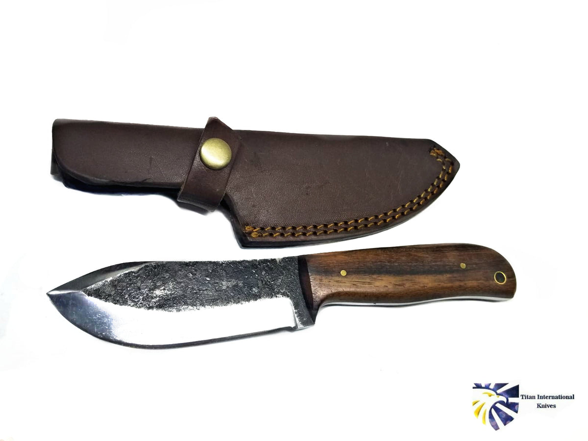 Hand Forged CUSTOM CARBON FORGED BLADE "Puma Skinner" knife with rosewood handle lying on a beige surface