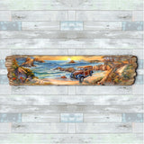 Long wooden art panel depicting a retro woody car parked on a coastal road beside rocky cliffs and blue ocean waves under a warm sunset sky.