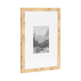 Rectangular picture frame with a light wood grain and natural knots, holding a black-and-white mountain landscape photo centered on a white mat background.