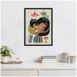 Framed canvas illustration of a black cat at a tea party with a colorful teapot and teacups on a green table, surrounded by plants and a hanging lamp.