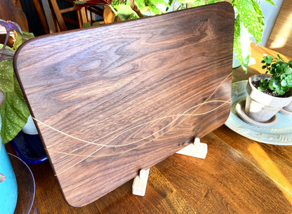 Peruvian Walnut charcuterie board with Maple and Cherry wood inlay on a table