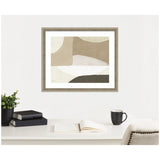 Framed abstract art print with overlapping beige, tan, white, and dark gray organic shapes hanging above a desk with black books, a plant, and a black coffee mug.