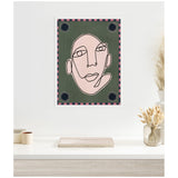 Minimalist abstract line drawing of a stylized face in black on a muted green background with pink and black checkered border and black floral corner accents.