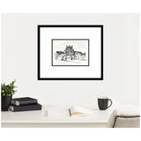 Black and white sketch of a Parisian building with trees, framed and hanging centered on a white wall above a desk with black books, a black mug, and an open notebook.