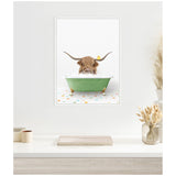 Framed canvas showing a Highland cow's head and horns emerging from a green clawfoot bathtub filled with bubbles, a yellow rubber duck on its head, colorful tiled floor below.