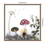 Framed canvas art of three detailed mushrooms with a red and white spotted cap, green cap, and small white cap, surrounded by dried botanical elements and moss.