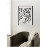 Black and white Henri Matisse line drawing titled 'Fille assise a table 1947' depicting a seated girl by a round table with fruit and plants, framed and hung on a white wall above a dark green armchair with a knitted throw.