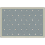 Rectangular pinboard covered in muted blue fabric with evenly spaced small cream botanical block print pattern, framed in simple light wood.