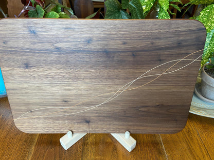 Handcrafted walnut charcuterie board with cherry and maple decorative banding